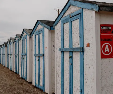 Gabled storage units with white walls and blue trim alongside a red "Building A" sign