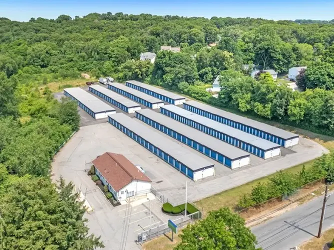 Aerial view of Storage Star Self-Storage in Providence, with several drive-up storage buildings with blue unit doors and an office building surrounded by trees