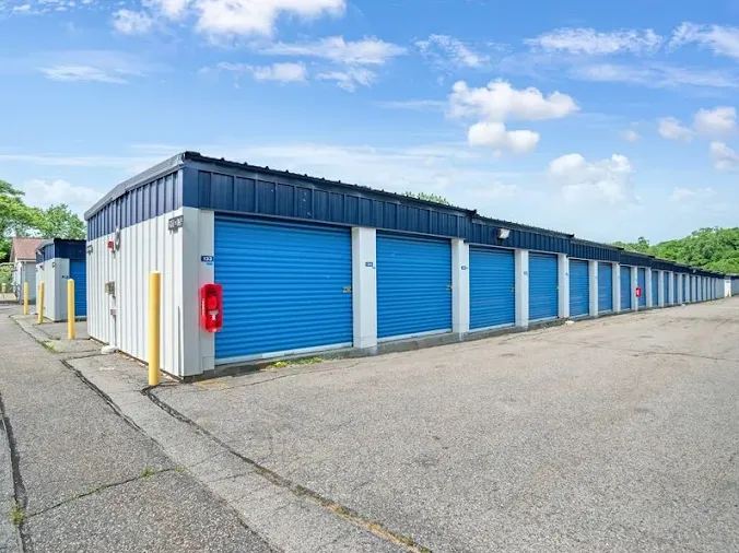 Row of outdoor drive-up storage units in Providence on Veazue St, with blue roll-up doors and a paved asphalt driveway