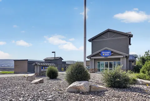Gray-sided facility office at Storage Star Self-Storage in Park City, UT, with glass doors and a blue Storage Star sign under a clear sky