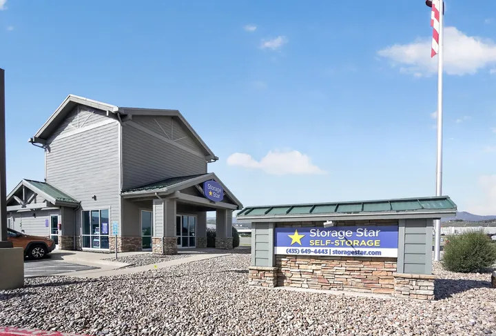 Monument sign facing exterior of office at Storage Star Self-Storage in Park City, Utah, featuring gray siding and a sidewalk