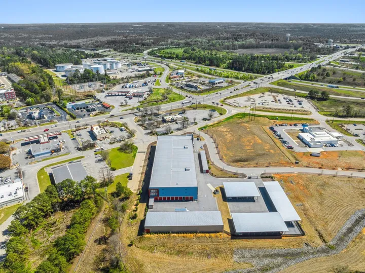 Aerial view of a multi-story self-storage building near a highway, with covered parking and drive-up units in North Augusta on Cork Tree Bend