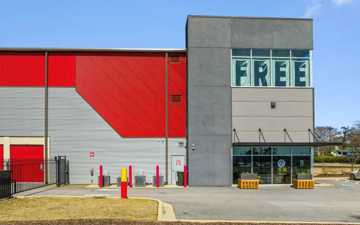 Modern storage building exterior featuring red and gray corrugated metal siding and a glass storefront office at Storage Star Self-Storage in North Augusta on Cork Tree Bnd