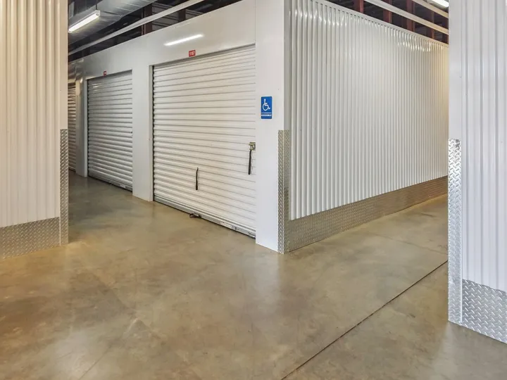 Indoor climate-controlled storage units in North Augusta on Cork Tree Bnd with white corrugated roll-up doors and a blue handicap accessible sign
