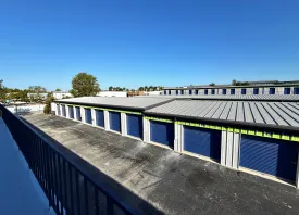 An upper-level view from a balcony of walk-up units looking down on an aisle of drive-up storage units in Marco Island, FL
