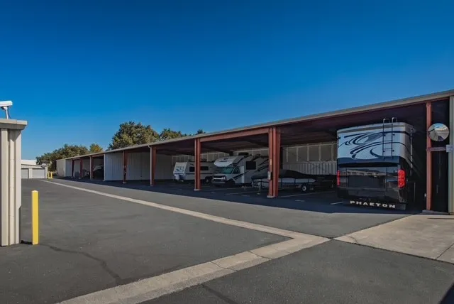 Outdoor covered vehicle storage in Woodland, CA, on Matmor Rd, with a paved driveway featuring parked RVs and boats