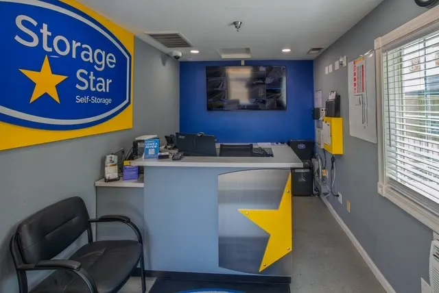 Woodland Storage Star rental office interior with a front desk, security monitor, black chair, and branded wall signage on Matmor Rd