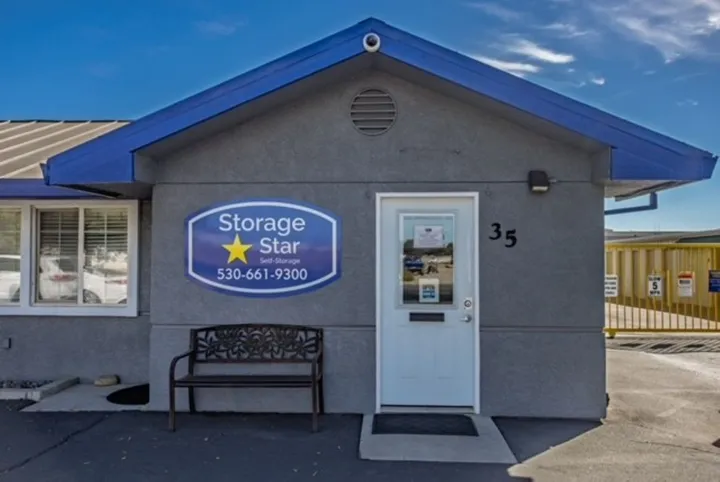 Exterior of a Storage Star rental office on Matmor Rd with a blue roof, white door, and metal bench