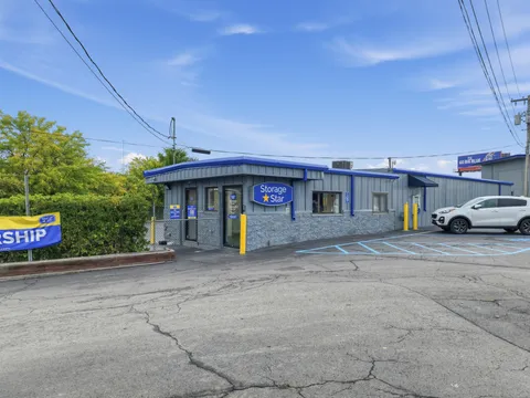 Exterior of the rental office at Storage Star in Albany on Central Ave with secure gated entry and yellow bollards under a blue sky