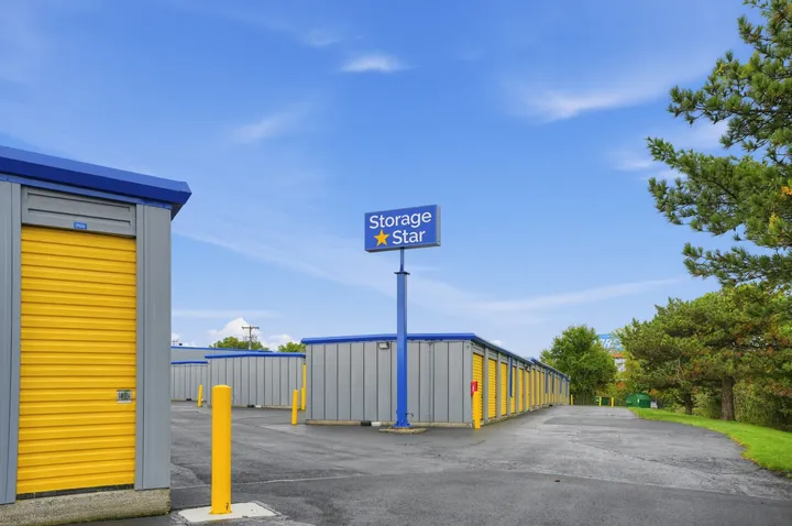 Outdoor drive-up storage units in Albany, NY, on Central Ave with yellow roll-up doors and a blue Storage Star pole sign