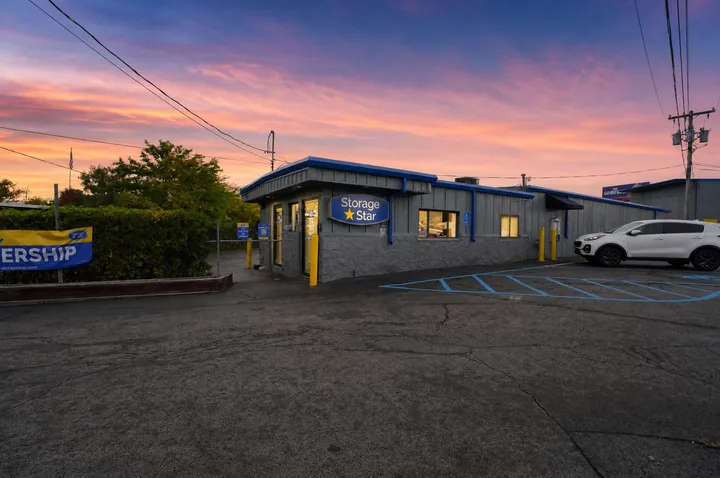 Exterior of the rental office at Storage Star in Albany on Central Ave with secure gated entry and yellow bollards at sunset