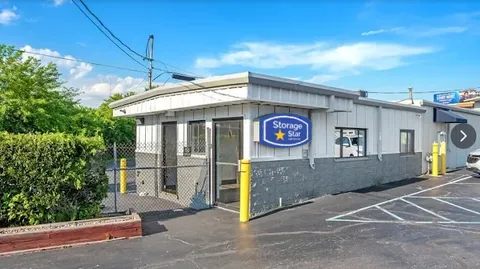Exterior of the rental office at Storage Star in Albany on Central Ave with secure gated entry and yellow bollards under a blue sky
