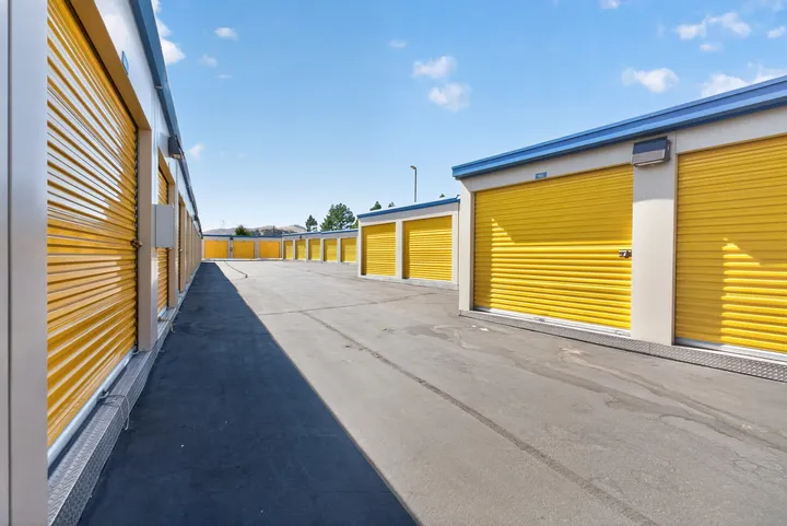 Outdoor drive-up storage in Fairfield on Lopes Rd, featuring rows of yellow roll-up doors and a wide asphalt driveway