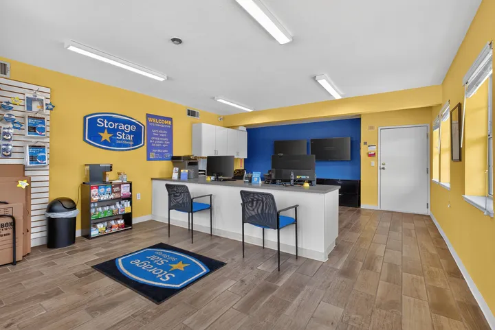 Office interior at Storage Star Self-Storage in Fairfield on Lopes Rd with a white front desk, computers, blue chairs, and yellow and blue walls