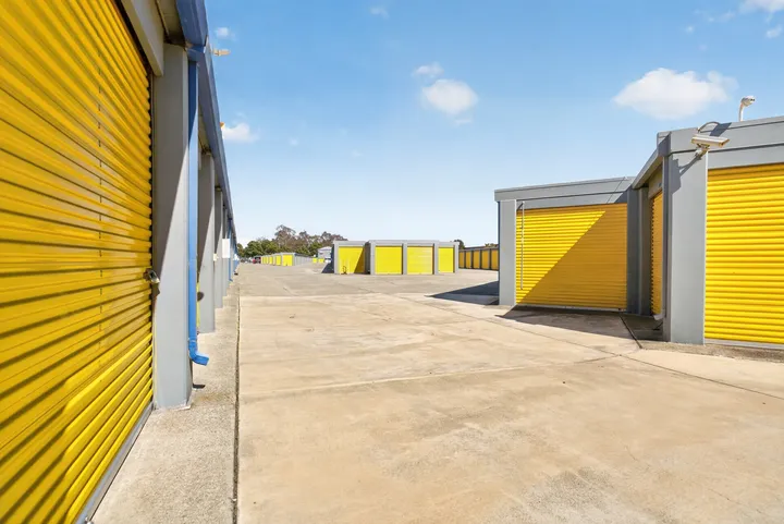 Outdoor drive-up storage at Storage Star Self-Storage in Fairfield on Lopes Rd, featuring multiple rows of gray buildings with bright yellow roll-up doors