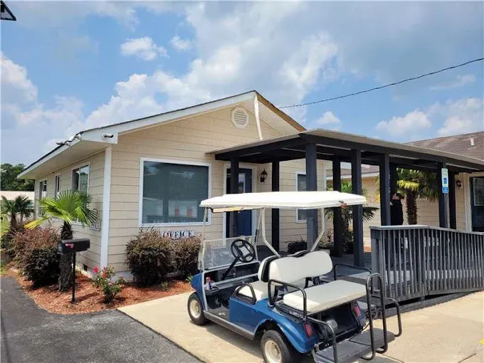 A blue golf cart parked in front of a tan storage facility office with a wooden ramp at Storage Star Self-Storage in Little River on SC-17