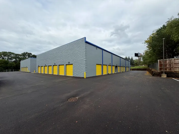 A row of drive-up self-storage units in West Chicago on Garys Mill Rd with yellow roll-up doors and gray brick siding