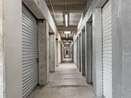 A long narrow hallway with climate-controlled storage units doors along both sides of corridor