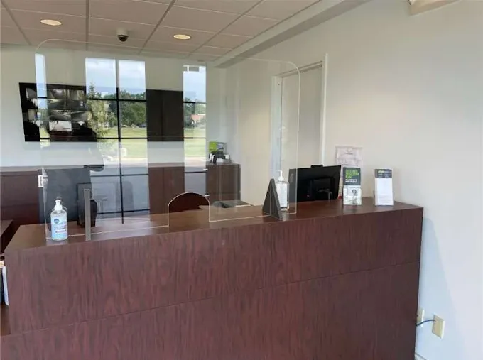 Storage Star self-storage rental office featuring a dark wood reception desk with clear acrylic protective partitions and hand sanitizer