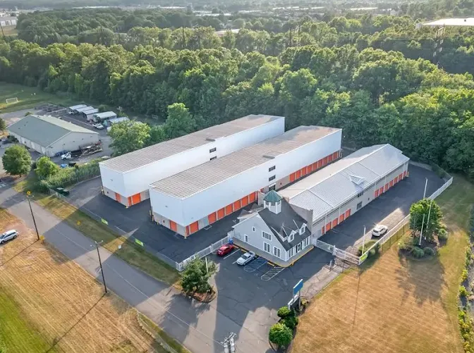 Aerial view of Storage Star North Brunswick storage facility with orange unit doors, a gated entrance, and rental office
