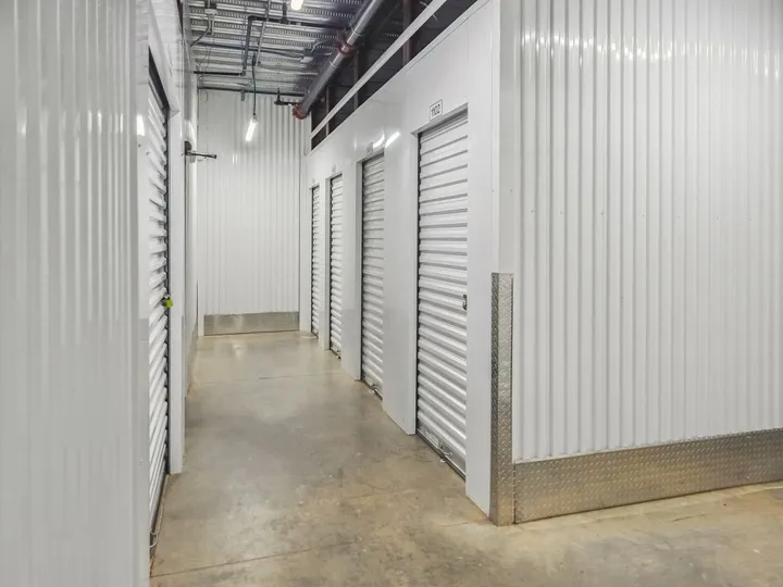 Indoor climate-controlled storage in Augusta on Cooper Dr with white corrugated metal walls, roll-up doors, and concrete flooring