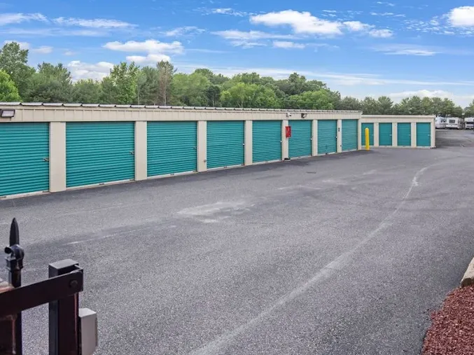 Row of outdoor drive-up storage units in Glassboro at 3200 Cross Keys Rd, with green roll-up doors along a wide asphalt driveway