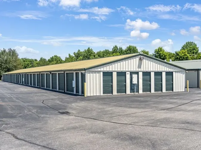 Outdoor drive-up self storage on Westpoint Boulevard building featuring long rows of dark green roll-up unit doors and asphalt driveway