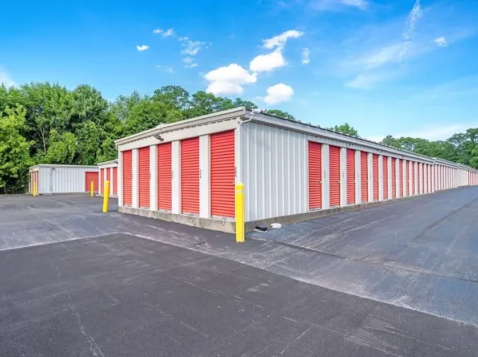 Outdoor drive-up storage units in Schenectady at 1110 Altamont Ave, featuring long rows of units with red roll-up doors and wide asphalt driveways