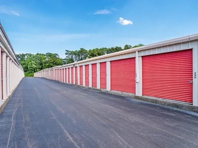 Drive-up self-storage in Schenectady, NY, with asphalt driveways and long rows of red roll-up metal doors