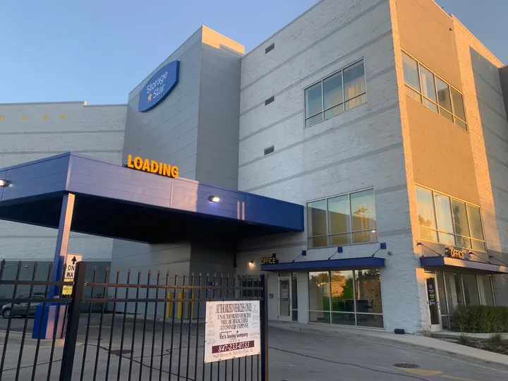 Multi-story Storage Star facility featuring a covered loading area, office entrance, and black metal security fence on N McCormick Blvd