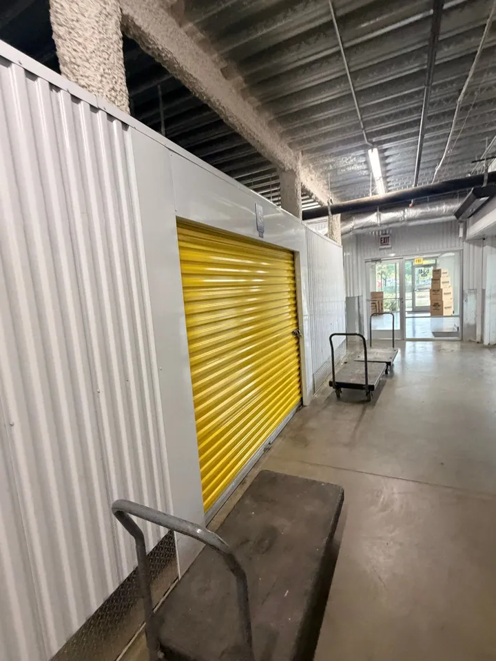 Hallway of climate-controlled storage units in Chicago, IL, with yellow roll-up doors and moving carts