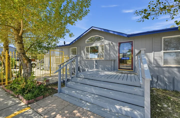Exterior of the Storage Star leasing office on Skyline Rd, featuring stairs, a front porch, and a glass front door with an hours decal