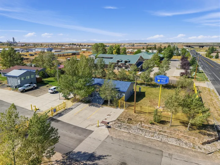 Aerial view of Storage Star Self-Storage in Laramie on Skyline Rd with a blue and gray office building, yellow fence, and large pylon sign