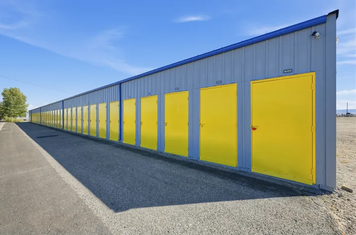 Row of yellow drive-up storage units in Laramie on Skyline Rd on a gray metal building under a blue sky