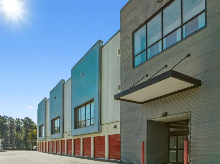 Multistory Storage Star self-storage facility featuring gray corrugated siding, blue facade accents, and a row of red drive-up storage units in Aiken on Hamilton Dr