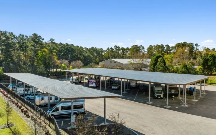 Aerial view of a paved lot and metal canopies with covered RV and boat storage in Aiken on Hamilton Dr