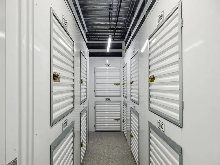 Indoor hallway featuring rows of white corrugated climate-controlled storage lockers in Aiken on Hamilton Dr