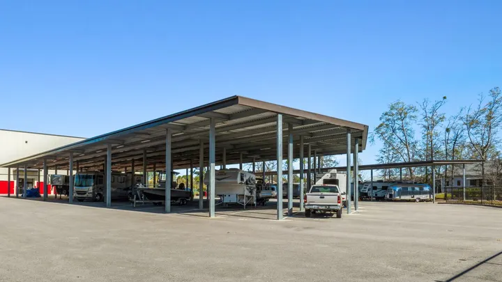 Outdoor covered vehicle storage in Aiken on Hamilton Dr, featuring a large metal canopy over boats, campers, and recreational vehicles
