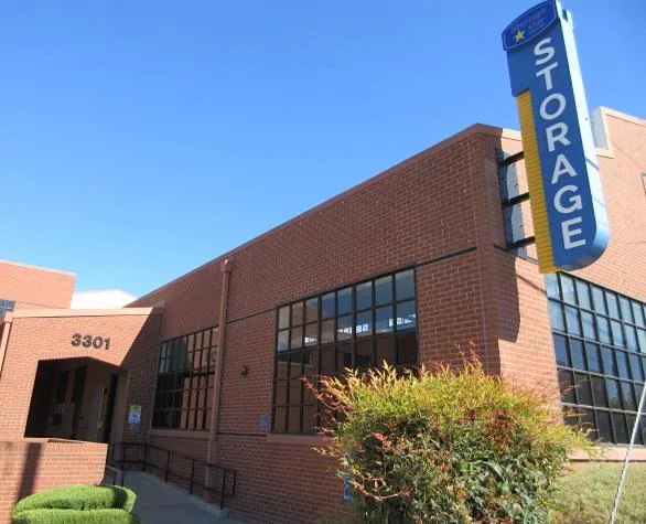 Red brick multi-story storage building with large windows and a blue Storage Star sign under a clear sky