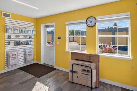 Storage facility office interior at Storage Star Self-Storage in Vacaville, with yellow walls, a rack of moving boxes, and views of outdoor units
