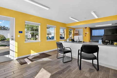 Storage facility rental office at Storage Star Self-Storage in Vacaville, CA, with yellow walls, a service counter, two chairs, and four windows