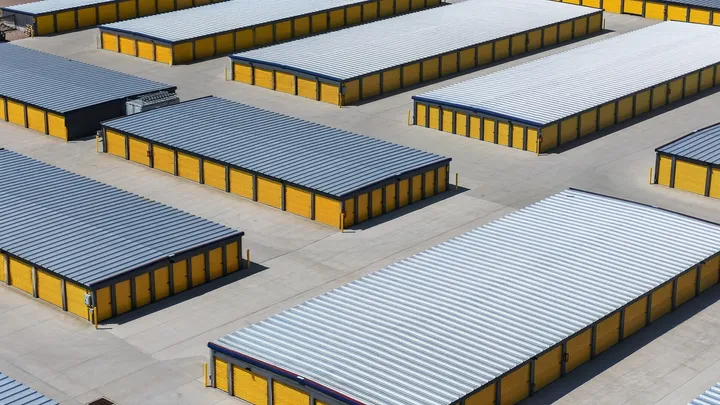 Elevated view of multiple drive-up storage units in Cheyenne, WY, on Wyott Dr, with yellow roll-up doors and corrugated metal roofs