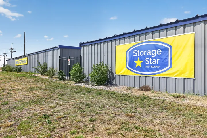 Exterior of gray metal buildings with a Storage Star sign and black metal security fence at Storage Star Self-Storage in Cheyenne at Wyott Dr