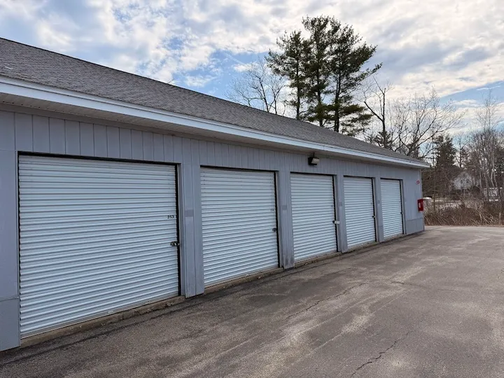 Exterior row of gray drive-up storage units at Storage Star in Yorke, ME, with white roll-up doors and a paved driveway