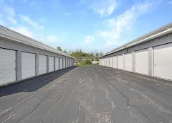 Rows of outdoor drive-up storage units with white roll-up doors