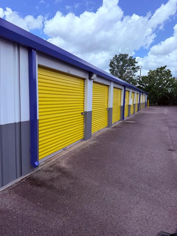 Outdoor drive-up self-storage units at Storage Star on Whiskey Rd with yellow roll-up doors and a blue roof