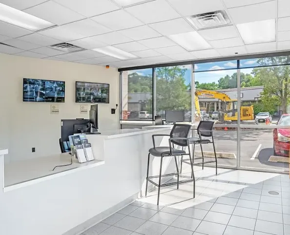 Storage Star self-storage rental office with a white counter, monitors for security cameras, and large windows looking outside