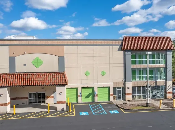 Exterior of Storage Star in Edison, NJ, with green roll-up doors, red tile roofing, and handicap parking spaces
