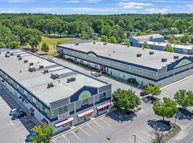 Aerial view of Storage Star Cinnaminson storage buildings with flat roofs surrounded by paved parking lots and greenery