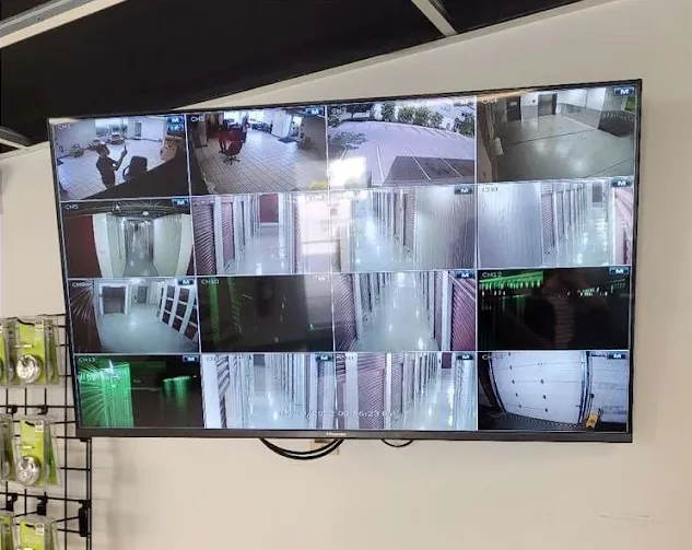 A wall mounted television screen displaying real time video feeds from multiple facility security cameras